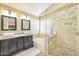 Spa-like bathroom featuring a tiled shower, soaking tub, and and sinks, offering a serene and relaxing experience at 2431 E Laurel St, Mesa, AZ 85213
