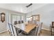 Sunlit dining room with a large wooden table and upholstered chairs under pendant lights at 2431 E Laurel St, Mesa, AZ 85213