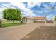 Front exterior showcasing a well-maintained home with a three car garage and long paver driveway at 2431 E Laurel St, Mesa, AZ 85213