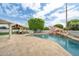 A sparkling pool with a rock waterfall and a shaded pergola seating area, ideal for relaxation at 2431 E Laurel St, Mesa, AZ 85213