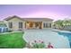 Backyard with covered patio, well-kept lawn, pool, and desert landscaping at 329 S Marin Dr, Gilbert, AZ 85296