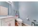 Powder room features a modern sink and toilet and soothing blue walls at 329 S Marin Dr, Gilbert, AZ 85296