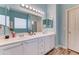 Bright bathroom with double sinks, white cabinets, and a large mirror with modern lighting at 329 S Marin Dr, Gilbert, AZ 85296