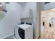 Laundry room with white washer and dryer units with overhead cabinets at 329 S Marin Dr, Gilbert, AZ 85296