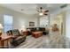 Inviting living room featuring wood-look floors, a leather sofa, and views into the kitchen at 329 S Marin Dr, Gilbert, AZ 85296