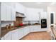 Well-lit kitchen featuring granite counters, stainless vent hood, and tile flooring at 404 E Coconino Pl, Chandler, AZ 85249