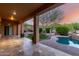 Spacious covered patio with travertine flooring, offering scenic backyard views at 41715 N River Bend Rd, Phoenix, AZ 85086