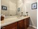 Bathroom vanity with wood cabinets, large mirror, decorative nautical accents, and framed artwork at 41715 N River Bend Rd, Phoenix, AZ 85086