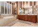 Bathroom featuring a soaking tub, double vanity, and stylish striped wall design at 41715 N River Bend Rd, Phoenix, AZ 85086