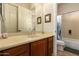 Bathroom features wood cabinets, a neutral countertop, and a framed mirror, plus a shower/tub combo at 41715 N River Bend Rd, Phoenix, AZ 85086