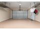 A clean and spacious garage with epoxy flooring, overhead storage racks and a refrigerator at 41715 N River Bend Rd, Phoenix, AZ 85086