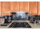 Close up of gas stove, granite countertops and tiled backsplash at 41715 N River Bend Rd, Phoenix, AZ 85086