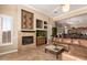 Elegant living room featuring a fireplace, custom built-ins, leather seating, and tile flooring at 41715 N River Bend Rd, Phoenix, AZ 85086