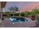 Enjoy this sparkling pool with a rock waterfall feature, surrounded by lush greenery and desert landscaping at 41715 N River Bend Rd, Phoenix, AZ 85086