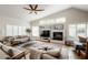 Spacious living room featuring a fireplace, large windows, a ceiling fan, and plush seating for comfort at 4230 E Fountain St, Mesa, AZ 85205