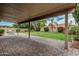 The covered patio looks out onto a lush, green lawn surrounded by mature landscaping at 4620 E Desert Cactus St, Phoenix, AZ 85032