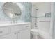 This bathroom features modern tiling, white cabinets and a beautiful round mirror at 4620 E Desert Cactus St, Phoenix, AZ 85032