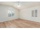Bedroom with vaulted ceiling, white walls, wood floors, ceiling fan, and windows with shutters at 4620 E Desert Cactus St, Phoenix, AZ 85032