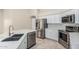Close-up shot of the kitchen showcasing stainless steel appliances, white cabinets, and tile flooring at 4620 E Desert Cactus St, Phoenix, AZ 85032