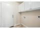 The laundry room has a white door, white cabinets and tile flooring at 4620 E Desert Cactus St, Phoenix, AZ 85032