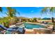 Beautiful backyard oasis featuring a pool, spa, lounge seating, and lush landscaping under a bright blue sky at 4865 S Cylinder Way, Mesa, AZ 85212
