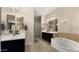Bathroom featuring double vanities, a chandelier, and a soaking tub at 4865 S Cylinder Way, Mesa, AZ 85212