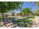 Lush green bocce ball court in a park-like setting with mature trees and seating at 4865 S Cylinder Way, Mesa, AZ 85212
