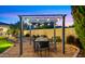 Charming outdoor dining area with overhead string lights, perfect for entertaining in the beautifully landscaped backyard at 4865 S Cylinder Way, Mesa, AZ 85212