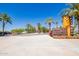 Community entrance sign with palm trees, flowers and well-maintained landscaping at 4865 S Cylinder Way, Mesa, AZ 85212