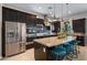 Modern kitchen boasts stainless steel appliances, dark wood cabinets, and a granite island with seating at 4865 S Cylinder Way, Mesa, AZ 85212