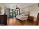 Spacious main bedroom with wood floors, ceiling fan, and multiple windows at 4865 S Cylinder Way, Mesa, AZ 85212