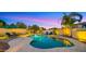 Luxurious pool and spa area with lounge chairs, umbrellas, palm trees, and beautiful lighting for relaxing evenings at 4865 S Cylinder Way, Mesa, AZ 85212
