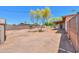 Expansive dirt backyard featuring mature tree, shed, and covered patio at 6502 E Rustic Dr, Mesa, AZ 85215