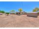 Spacious dirt backyard includes mature trees and a storage shed at 6502 E Rustic Dr, Mesa, AZ 85215