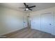 Light and airy bedroom with a ceiling fan, closet, and wood-look floors at 6502 E Rustic Dr, Mesa, AZ 85215