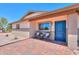 Charming home entrance with blue door, brick walkway and patio furniture at 6502 E Rustic Dr, Mesa, AZ 85215