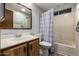 Bathroom featuring a single sink vanity with wood cabinets, a mirror, and a tub/shower combo at 661 S Hawes Rd # 81, Mesa, AZ 85208