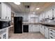 Functional kitchen offering white cabinets, black appliances, and tile flooring at 661 S Hawes Rd # 81, Mesa, AZ 85208