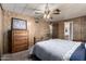 Cozy main bedroom featuring wood-paneled walls, a ceiling fan, and ample closet space at 661 S Hawes Rd # 81, Mesa, AZ 85208