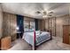 Comfortable main bedroom with a metal frame bed, wood-paneled walls, and a ceiling fan at 661 S Hawes Rd # 81, Mesa, AZ 85208