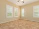 Neutral bedroom featuring tile floors, cream walls, large windows, and a ceiling fan at 882 E Parkview Dr, Gilbert, AZ 85295