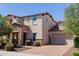 Charming two-story home featuring a stone facade, well-manicured landscaping, and a brick driveway at 882 E Parkview Dr, Gilbert, AZ 85295