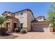 Attractive two-story home featuring a stone facade, well-manicured landscaping, and a brick driveway at 882 E Parkview Dr, Gilbert, AZ 85295