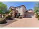 Inviting two-story home with stone accents, landscaping, and a brick driveway leading to a two-car garage at 882 E Parkview Dr, Gilbert, AZ 85295