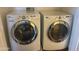 Well-maintained laundry room with modern, white front-load washer and dryer units at 882 E Parkview Dr, Gilbert, AZ 85295