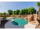 Gorgeous pool area with rock waterfall, steps and lush greenery in a private backyard setting at 882 E Parkview Dr, Gilbert, AZ 85295