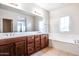 Bathroom with a dual sink vanity, a soaking tub, and tile flooring at 15387 W Columbine Dr, Surprise, AZ 85379