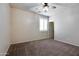 Neutral bedroom with carpet, a ceiling fan, a window with white shutters, and a view to an open doorway at 15387 W Columbine Dr, Surprise, AZ 85379