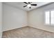 Clean, bright bedroom features neutral carpet, a ceiling fan, and a shuttered window at 15387 W Columbine Dr, Surprise, AZ 85379