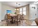 Staged dining room with a chandelier, neutral colors, and a side-entry door at 15387 W Columbine Dr, Surprise, AZ 85379